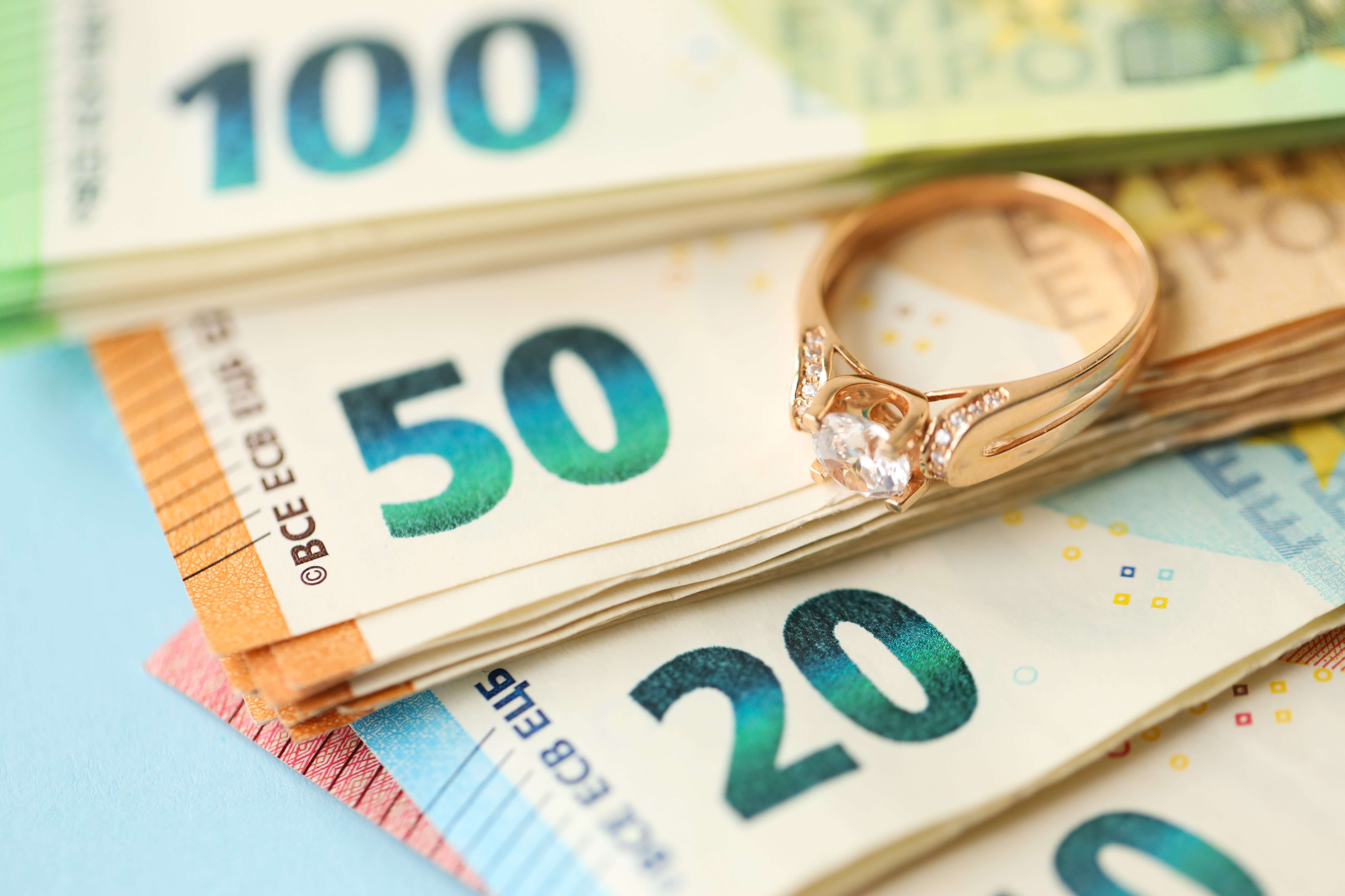 Euroscheine und ein goldener Ring mit Diamant